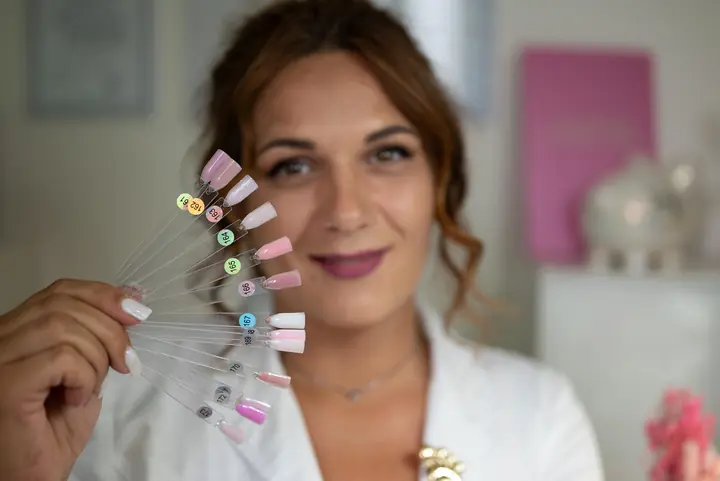 Kristina Kutá s vějířem vzorků barev na nehty